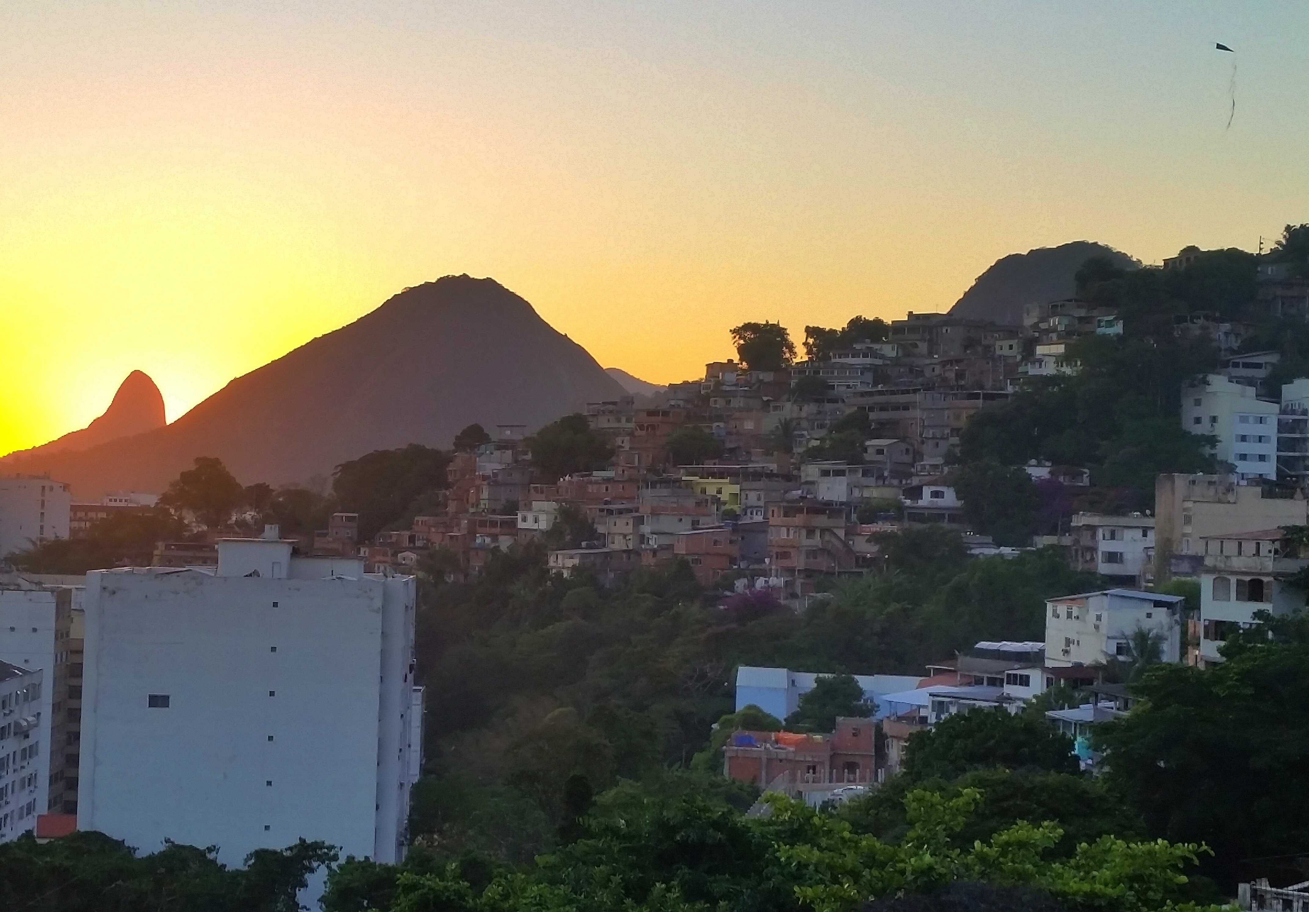 Is it safe for tourists to visit the favelas in Rio de Janeiro? - A glowing sunset over a favela in Rio de Janeiro