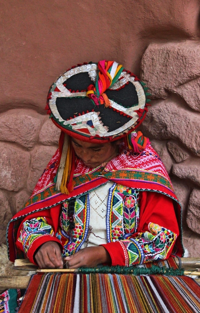 An indigenous woman in the Andes weaving- Insider’s Guide: Essential Peru Travel Tips You Need To Know Before Visiting