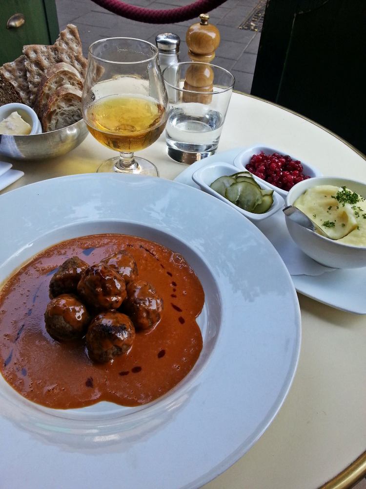 Swedish Meatballs with mashed potatoes, lingonberries, pickles, fresh rye bread, and Swedish beer at Bistro Jarl Restaurang. -Stockholm Travel Guide